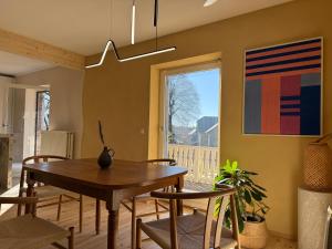 a dining room with a table and chairs and a window at Rainbow Bungalow in Butgenbach
