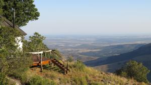 a bench on the side of a hill with a view at The Edge Mountain Retreat in Hogsback