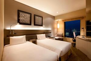 a hotel room with two beds and a window at The Royal Park Hotel Iconic Tokyo Shiodome in Tokyo