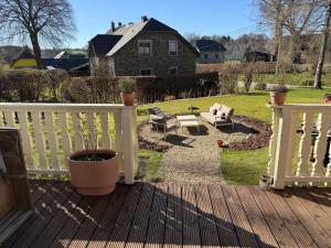 a porch with a white fence and a patio at Rainbow Bungalow in Butgenbach