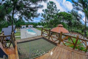 ein Käfig auf einer Holzterrasse neben einem Pool in der Unterkunft Chalé do Rista in Suzano + 7 Fotos