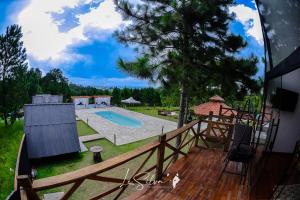 ein Haus mit Holzterrasse und Swimmingpool in der Unterkunft Chalé do Rista in Suzano