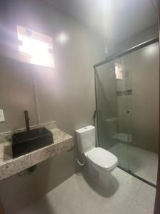 a bathroom with a toilet and a sink and a shower at Hotel Lorenna in Santa Inês