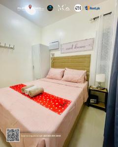 a bedroom with a large bed with a red blanket at CENIA UNIT Staycation House in Dauis