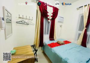 a small room with a bed and a table at CENIA UNIT Staycation House in Dauis