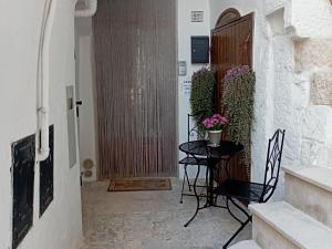 a hallway with a table and chairs and a door at Casa Checco in Cisternino