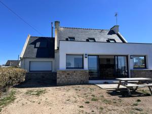 a house with a picnic table in front of it at Maison d'exception face à l'océan in Lampaul-Plouarzel +16 photos