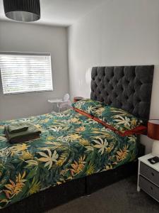 a bedroom with a bed with a floral bedspread at Evas place in Llandudno