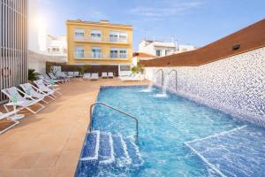 a swimming pool on the side of a building at Neptuno Aparthotel in Calella