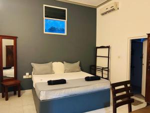 a bedroom with a large bed with two pillows on it at Hotel Marilyn in Negombo
