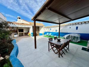 an outdoor patio with a wooden table and chairs at Alojamiento Rural La Tinaja in Ayna