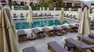 a swimming pool with lounge chairs and umbrellas at 7 Brothers Hotels in Marmaris