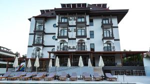 a building with chairs and umbrellas in front of it at 7 Brothers Hotels in Marmaris