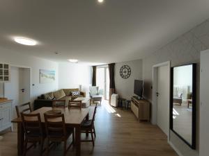 a living room and dining room with a table and a couch at PINEA 2 BEDROOM APARTMENT WITH Sea VIEW in Pobierowo