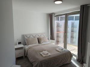 a bedroom with a large bed with towels on it at PINEA 2 BEDROOM APARTMENT WITH Sea VIEW in Pobierowo +14 photos