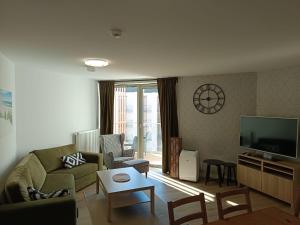 a living room with a couch and a tv at PINEA 2 BEDROOM APARTMENT WITH Sea VIEW in Pobierowo