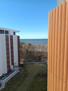 an external view of a building with the ocean in the background at PINEA 2 BEDROOM APARTMENT WITH Sea VIEW in Pobierowo