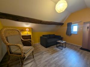 a living room with a chair and a couch at Gîte simone de beauvoir in Châteauvillain