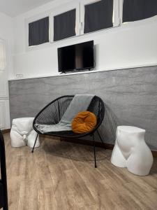 a wicker chair with a orange pillow on it at B&B La Fenice Suite in Salerno +29 photos