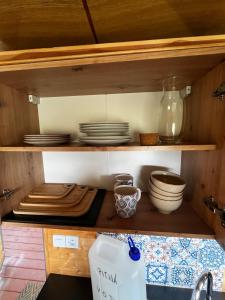 a kitchen with plates and bowls on a shelf at Mája u lomu in Stachlovice