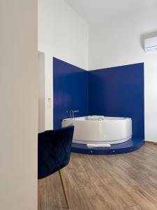 a bathroom with a white tub and a blue wall at B&B La Fenice Suite in Salerno