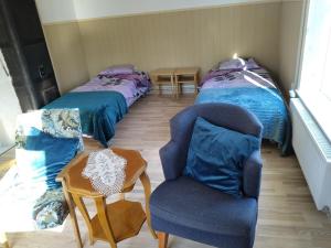 a room with two twin beds and a chair at Parkal Apartments in Paide
