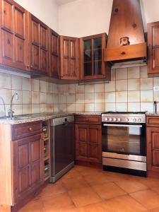 a kitchen with wooden cabinets and a stove at Tenuta Domine in Imperia