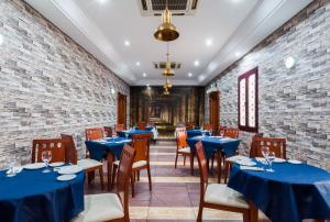 a restaurant with blue tables and chairs and a brick wall at Hotel Victoria in Linares
