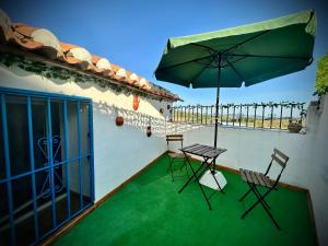 a patio with a table and chairs and an umbrella at Alojamiento Rural La Tinaja in Ayna +50 photos