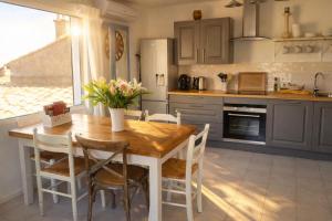 a kitchen with a wooden table and chairs at Maison de Thau in Mèze