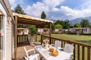 a wooden deck with a table and chairs and tents at Club del Sole Due Laghi Levico Family Collection in Levico Terme
