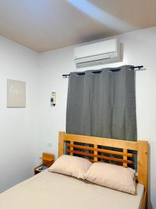 ein Schlafzimmer mit einem Bett und einem Fenster mit einem Vorhang in der Unterkunft Zleep Inn in San Juan