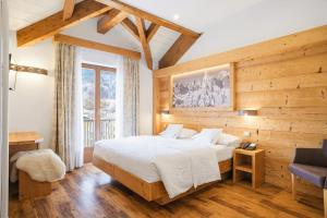 a bedroom with a bed and a wooden wall at Hotel La Bussola in Andalo +55 photos