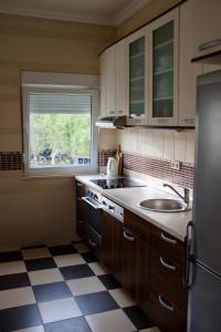 a kitchen with a sink and a stove and a window at Apartman Spanish Square in Mostar