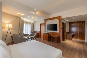 a hotel room with a bed and a flat screen tv at Clarks Inn Bokaro in Bokāro