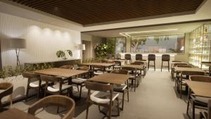 a restaurant with tables and chairs in a room at Laghetto Stilo Aeroporto in Porto Alegre