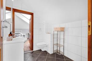 a white bathroom with a toilet and a sink at Villa Stavanger 5 bedrooms 5 bathrooms and large swimming pool in Stavanger +18 photos