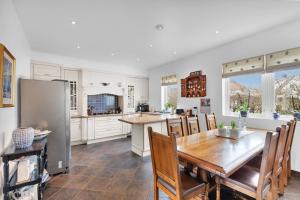a kitchen with a table and a refrigerator at Villa Stavanger 5 bedrooms 5 bathrooms and large swimming pool in Stavanger
