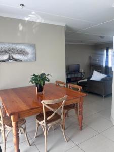 a dining room with a wooden table and chairs at Modern , Spotless Townhouse in Quiet Estate - Pietermaritzburg in Pietermaritzburg