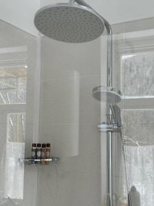 a shower with a glass door and a shower head at Authentic house with a huge garden in Utsera