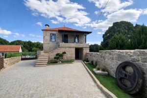 a stone house with a statue in front of it at Refugio dos Coviais in Guarda