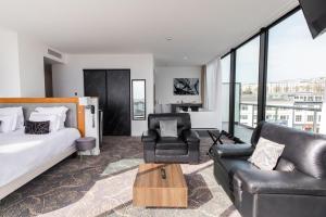 a bedroom with a bed and a couch and a chair at Le Barracuda & Spa, pieds dans l'eau, vue mer, espace bien-être offert in Brest