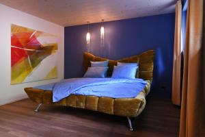 a bed in a room with a blue wall at BLUE-art Ferienwohnung in Wyssachen