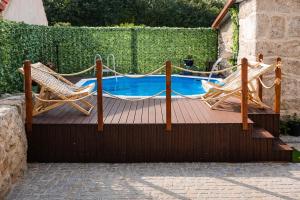 two chairs and a hammock next to a pool at Refugio dos Coviais in Guarda