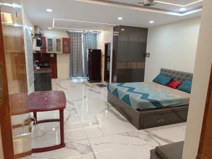 a bedroom with a bed and a table and a kitchen at Ganesh Nilayam in Hyderabad