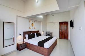 a bedroom with a large bed and a mirror at Hotel Vijai Square in Prayagraj