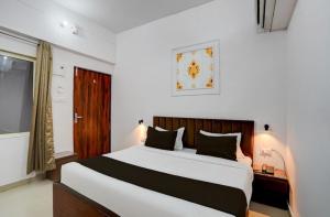 a bedroom with a large bed and a window at Hotel Vijai Square in Prayagraj +8 photos