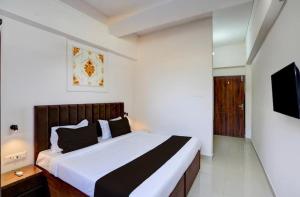 a bedroom with a large bed and a television at Hotel Vijai Square in Prayagraj