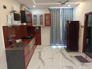 a kitchen with a sink and a refrigerator at Ganesh Nilayam in Hyderabad