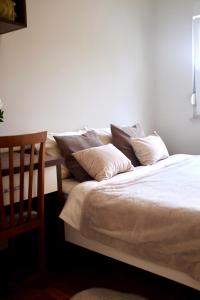 a bed with pillows on it in a room at Apartman Spanish Square in Mostar